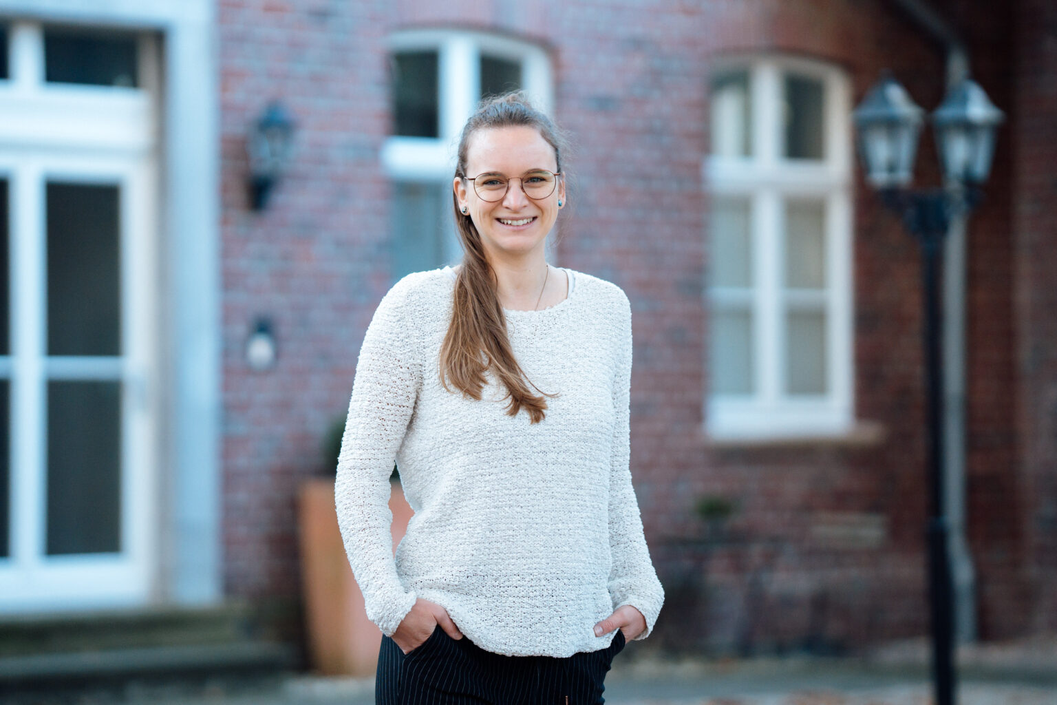 Porträt von Denise Di Dio, Psychologische Psychotherapeutin für Verhaltenstherapie in Willich, aufgenommen im Innenhof des Vierkanthofs auf dem sich die Praxis befindet.